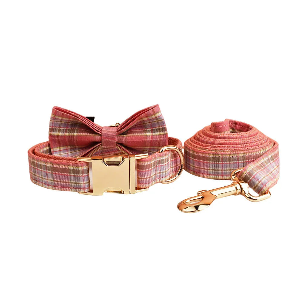 Plaid cloth fabric dog collar, vest, bow tie, and leash set laid out flat.