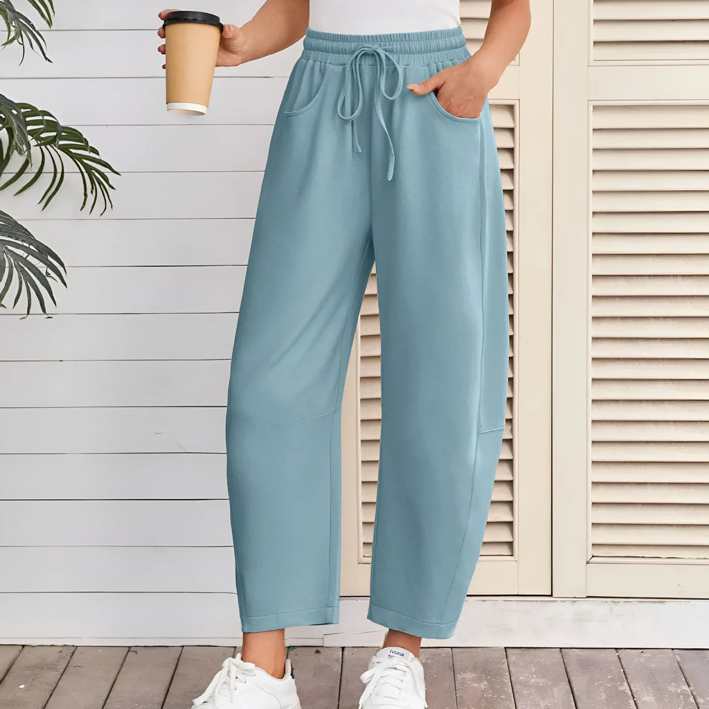 Loose fit cropped sweatpants in apricot colour with drawstring waist and side pockets on a neutral background.