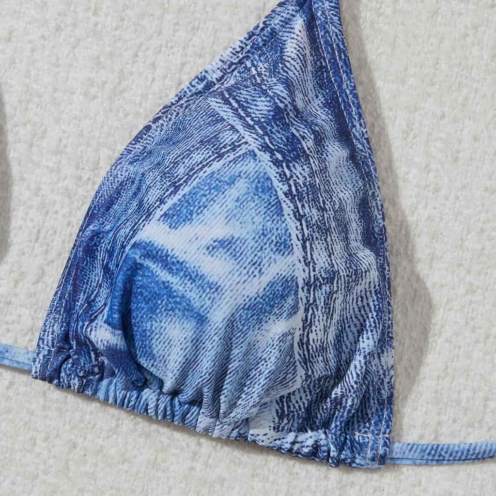Denim blue printed women's bikini set with strap design, shown on a model.