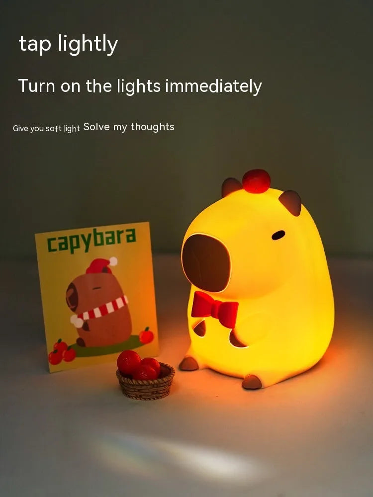 Small grey capybara-shaped silicone night lamp on a table.