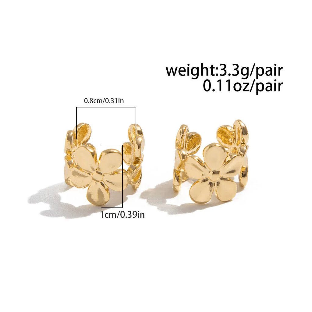 Women's gold starfish and conch shell drop earrings on a white background.