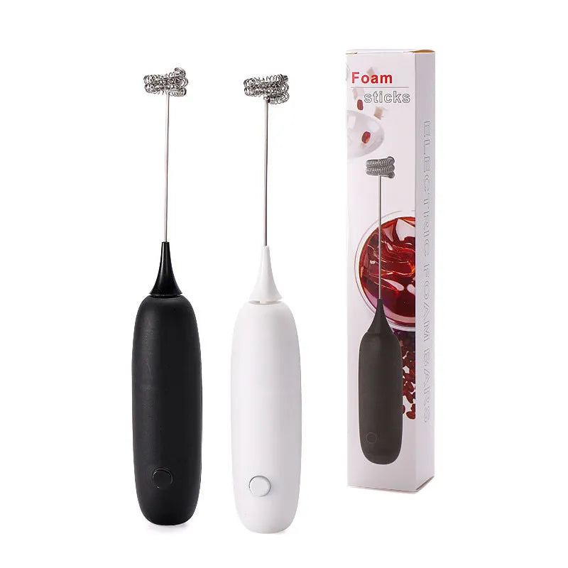 Black and white electric hand-held milk frother for coffee preparation on kitchen counter
