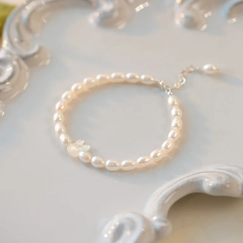 White rabbit bracelet with small pearl beads on an elastic string, silver rabbit charm.