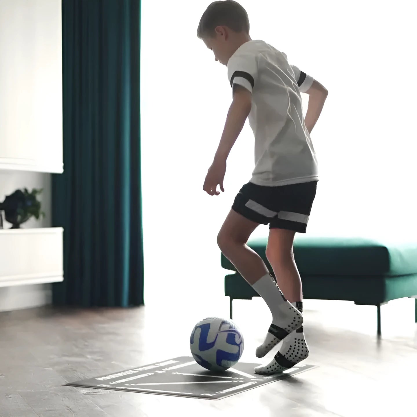 Black rectangular football training mat on grass for skills practice.