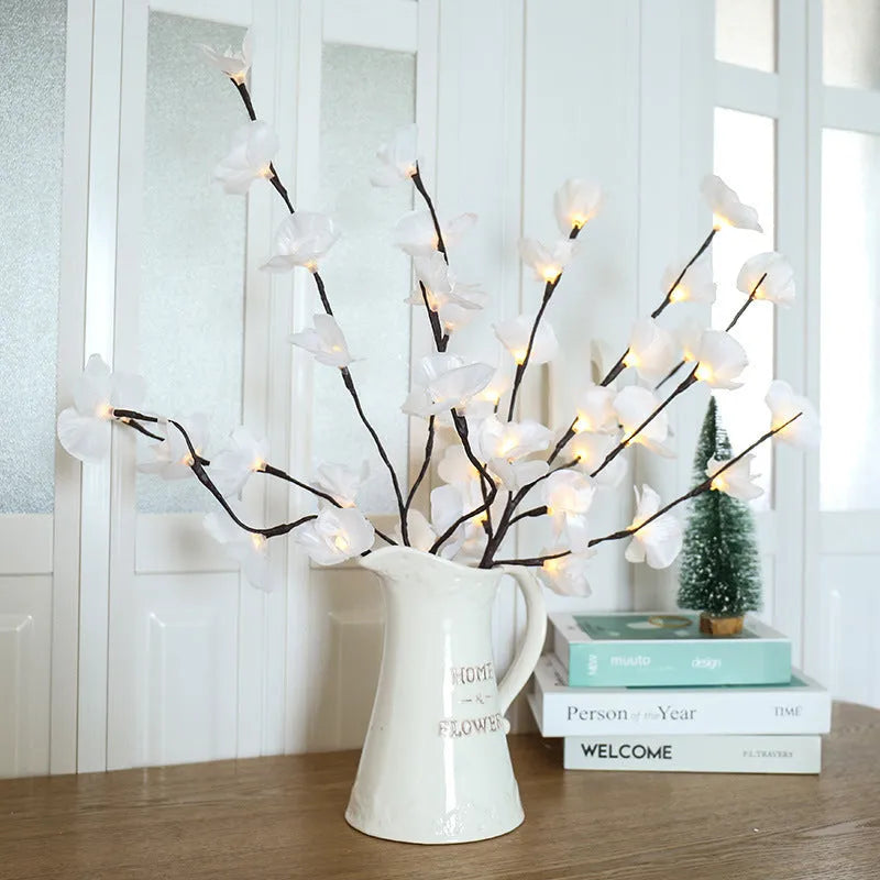 Pink LED phalaenopsis orchid branch decorative light on a table, 65 cm long with fabric leaves.