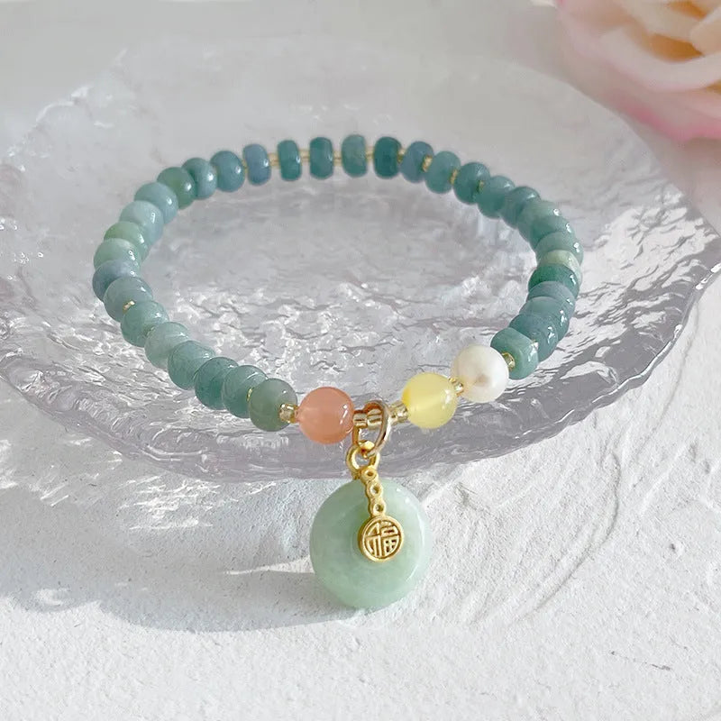 Blue-toned jade bracelet with gourd and peace buckle charms and strawberry quartz accents