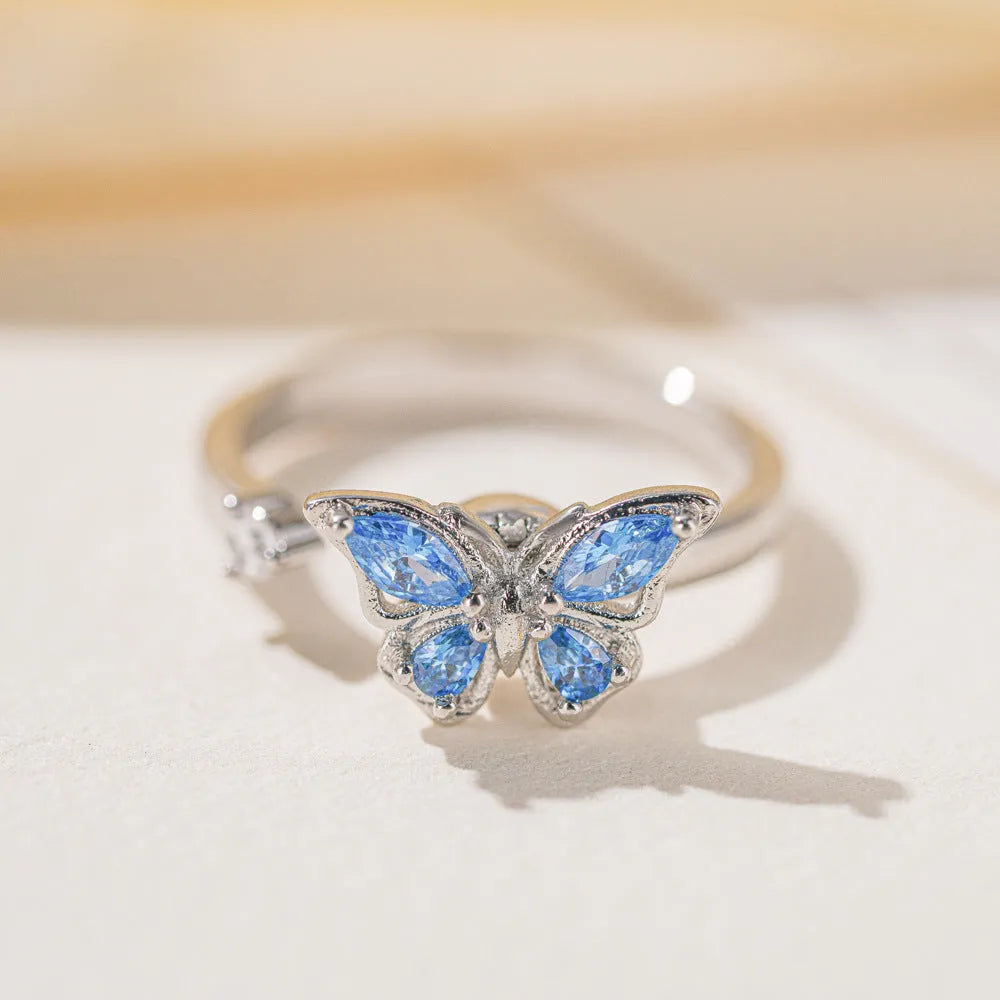 Butterfly adjustable ring with electroplated white gold finish and blue diamond accent on copper base