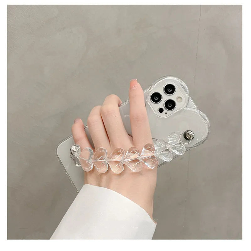 Transparent iPhone case with a love heart charm on a chain, on an iPhone.