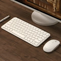Mute ultra-thin wireless white keyboard and mouse set with USB receiver on a desk.
