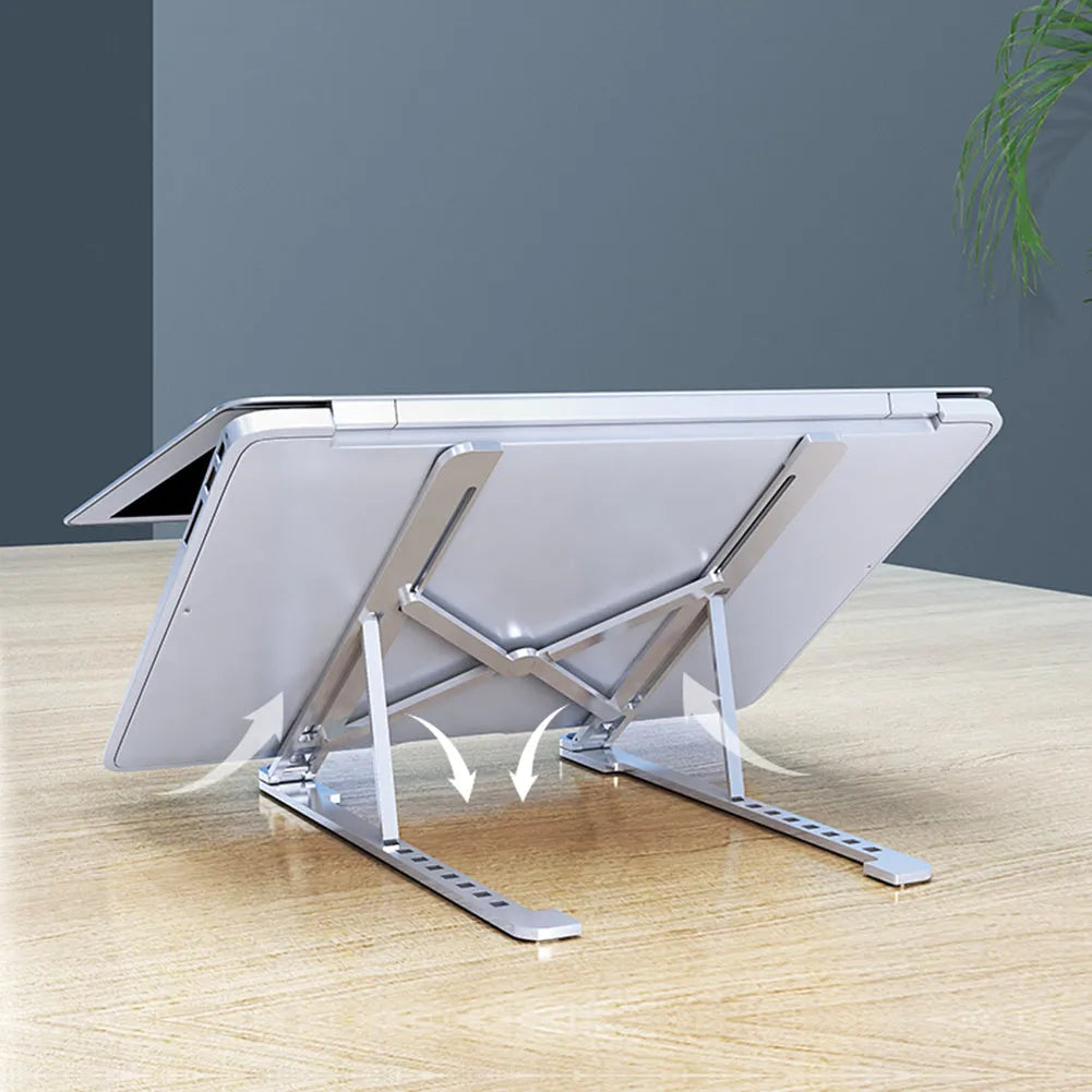 Foldable aluminium laptop stand in silver, shown supporting a laptop at an angle.