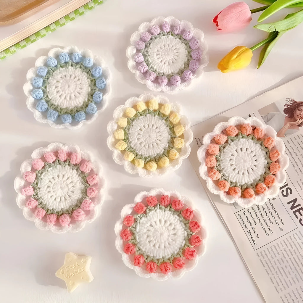 Handmade crocheted flower coaster in cotton and linen yarn, showing pink, purple, red, and yellow colour options.
