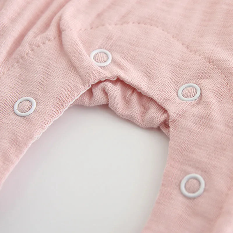 Pink baby girl's embroidered long sleeve cotton jumpsuit on a hanger
