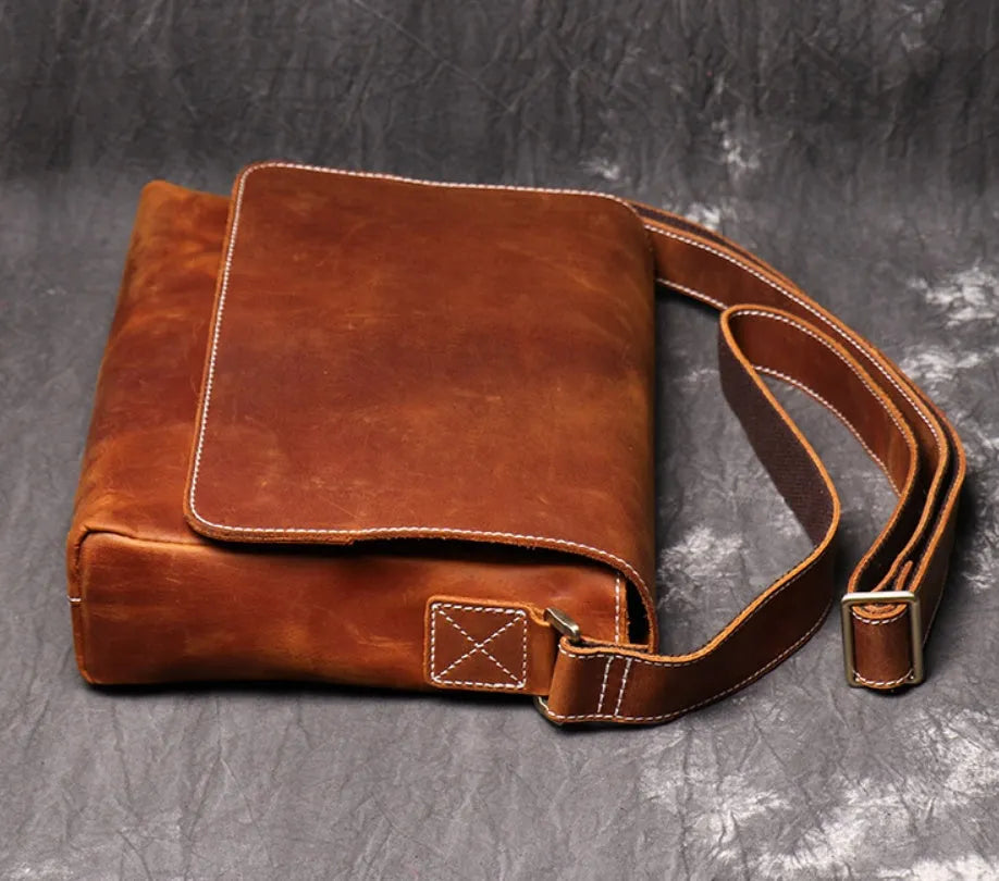 Men's vintage brown cowhide shoulder bag showing medium size and cross-body strap