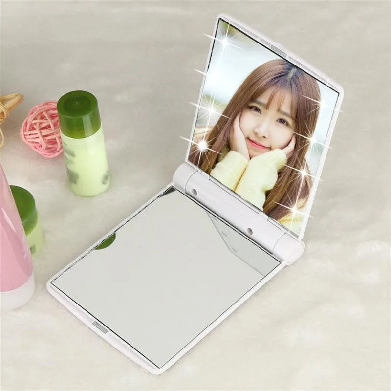 Folding LED pocket cosmetic mirror in Black, closed and open to show LEDs and compact size