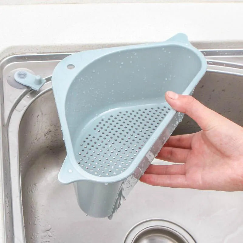 Beige and blue plastic triangle sink storage rack with suction cups holding a sponge