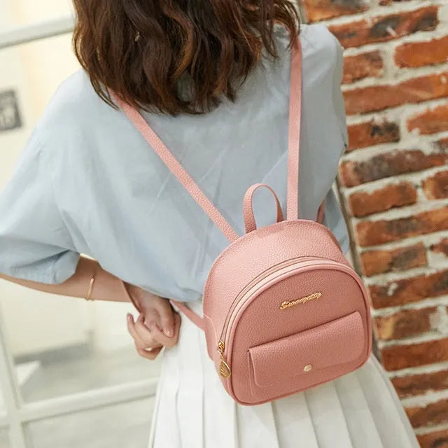 Black PU leather small women's backpack with zipper, shown as a shoulder bag.