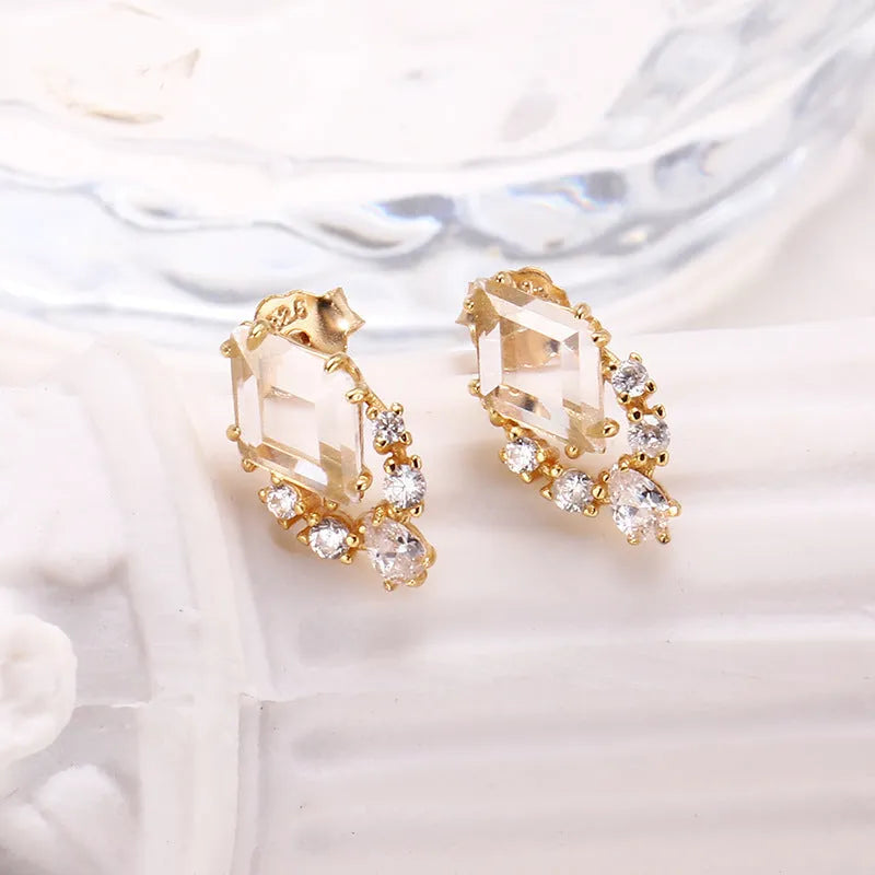 Geometric sterling silver earrings with sweet white crystal studs on white background