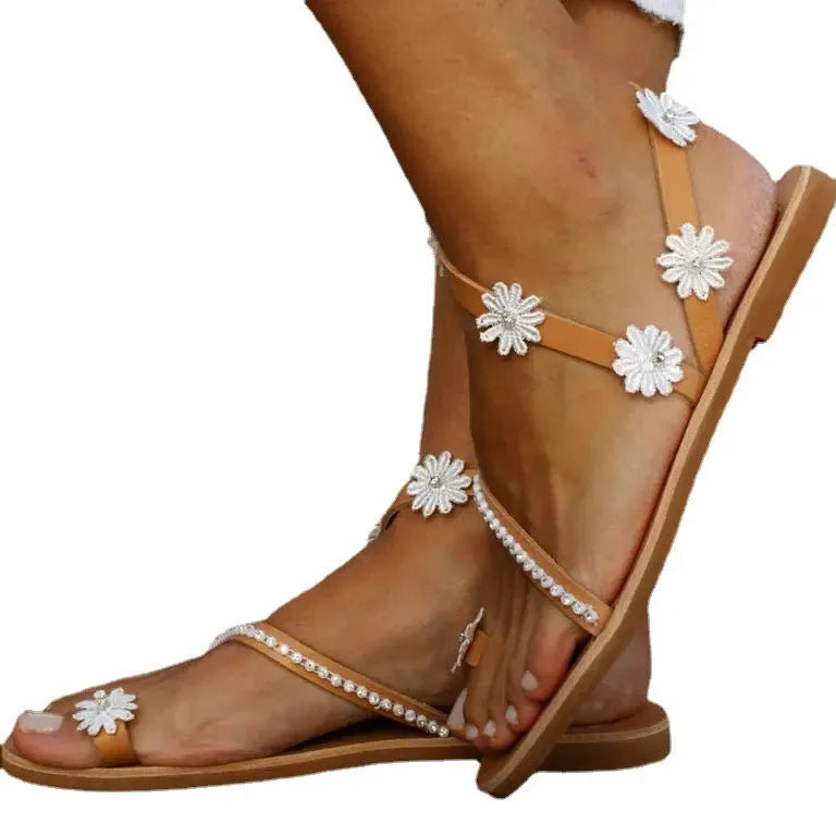 Brown women's flat Roman sandals with floral decoration and herringbone toe.