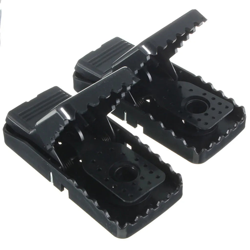 Set of six black plastic snapping mousetraps showing size and smooth surface