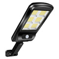 Black outdoor solar-powered security light with motion sensor on a wall.