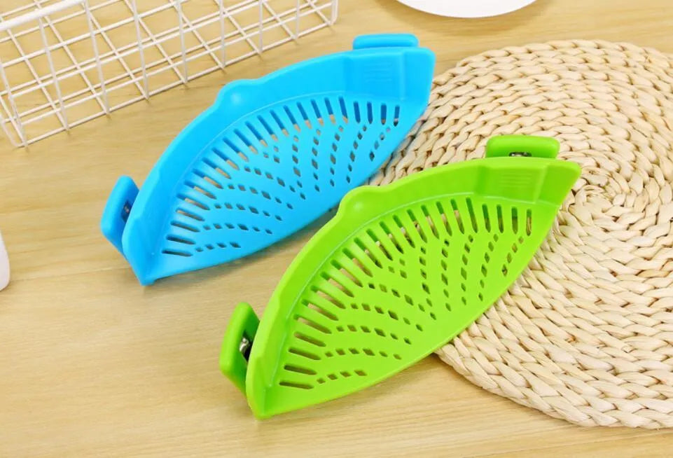 Silicone clip-on kitchen strainer with stainless steel frame attached to pot rim for draining liquids