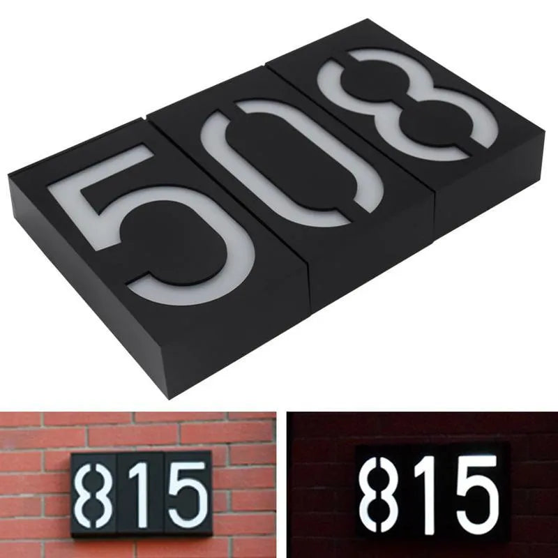 Solar powered LED illuminated house number plate with white digits, for outdoor wall mounting.