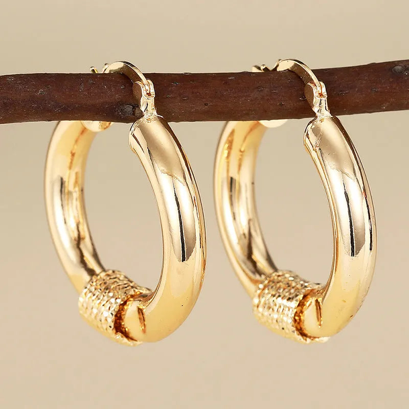 Geometric copper earrings for women featuring ring and line design in a golden colour.