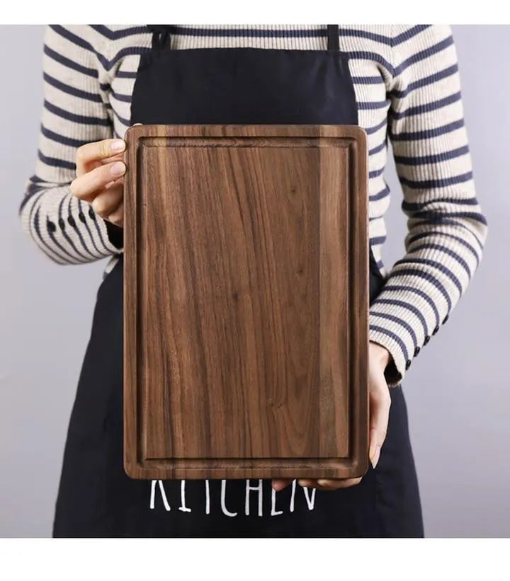 Solid black walnut wood chopping board with a deep perimeter groove and a side handle, shown as a serving tray.