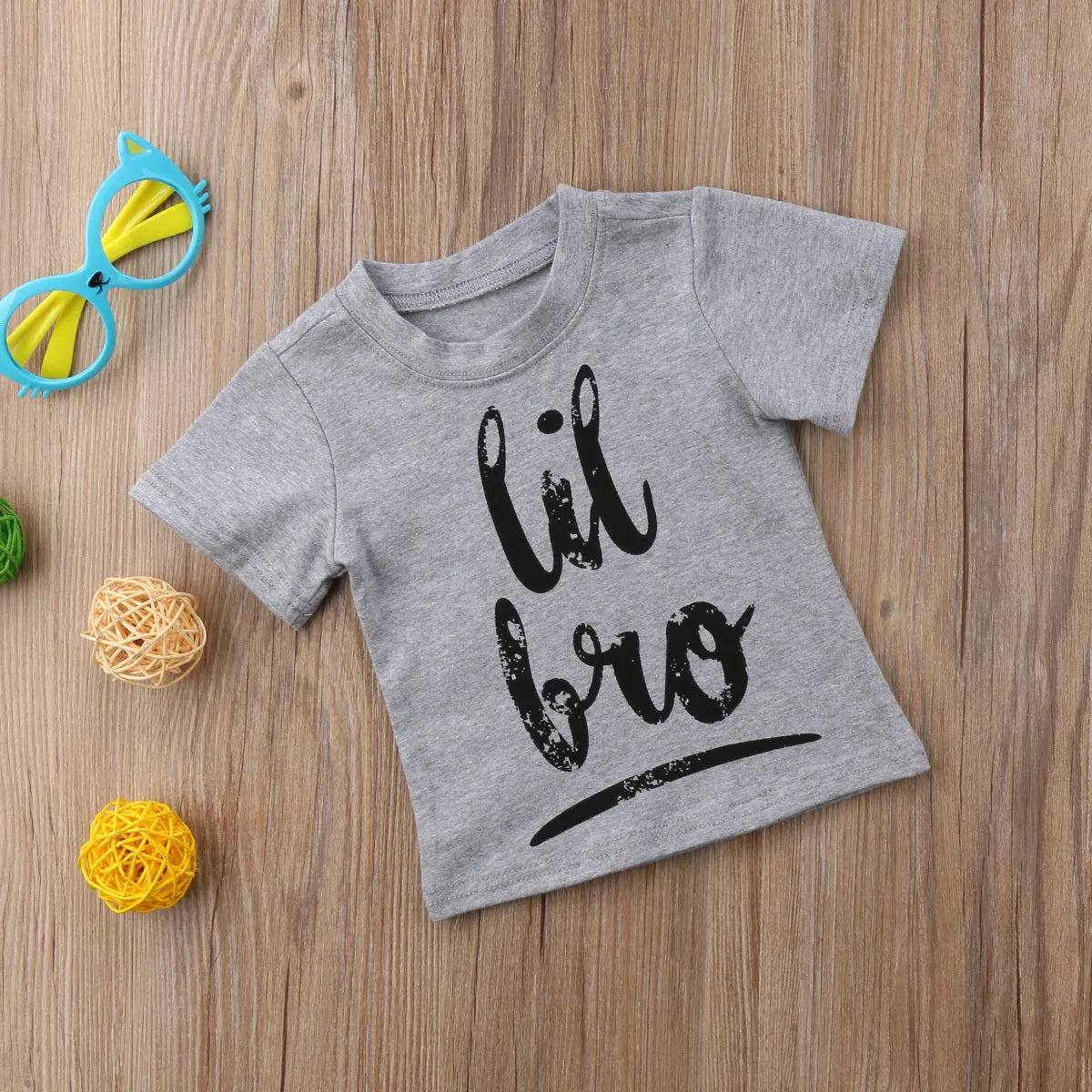 Grey cotton children's t-shirt with printed sibling graphic, showing size range from 60cm to 140cm.