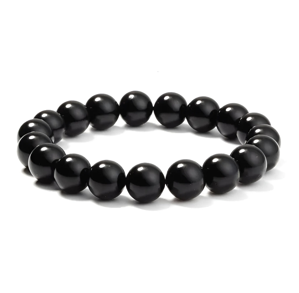 Close-up of a black agate bracelet with 8mm geometric beads on a black elastic cord.