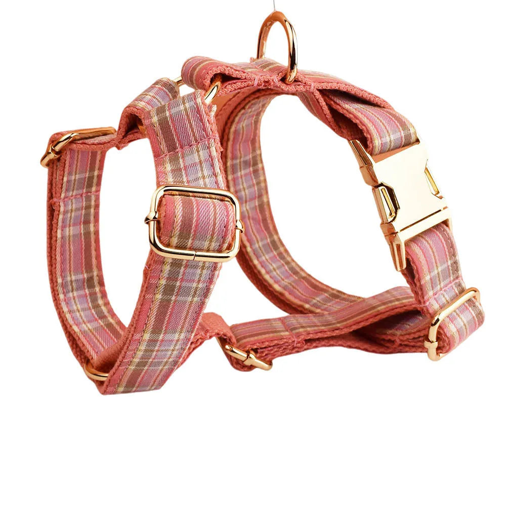 Plaid cloth fabric dog collar, vest, bow tie, and leash set laid out flat.