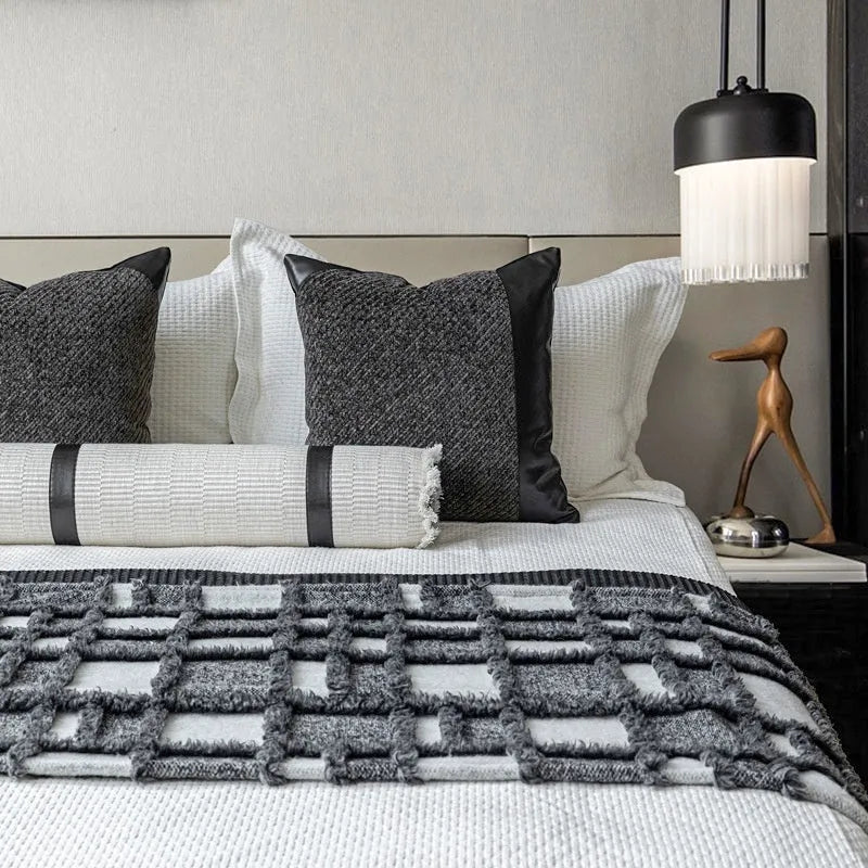 Modern grey and white plaid bed runner blanket set with a matching pillowcase and round pillow on a double bed.