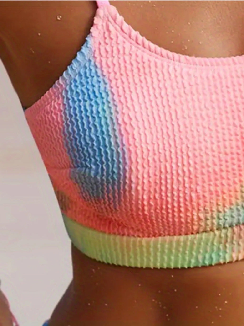 Women's orange and blue tie-dye pleated bikini on a white background