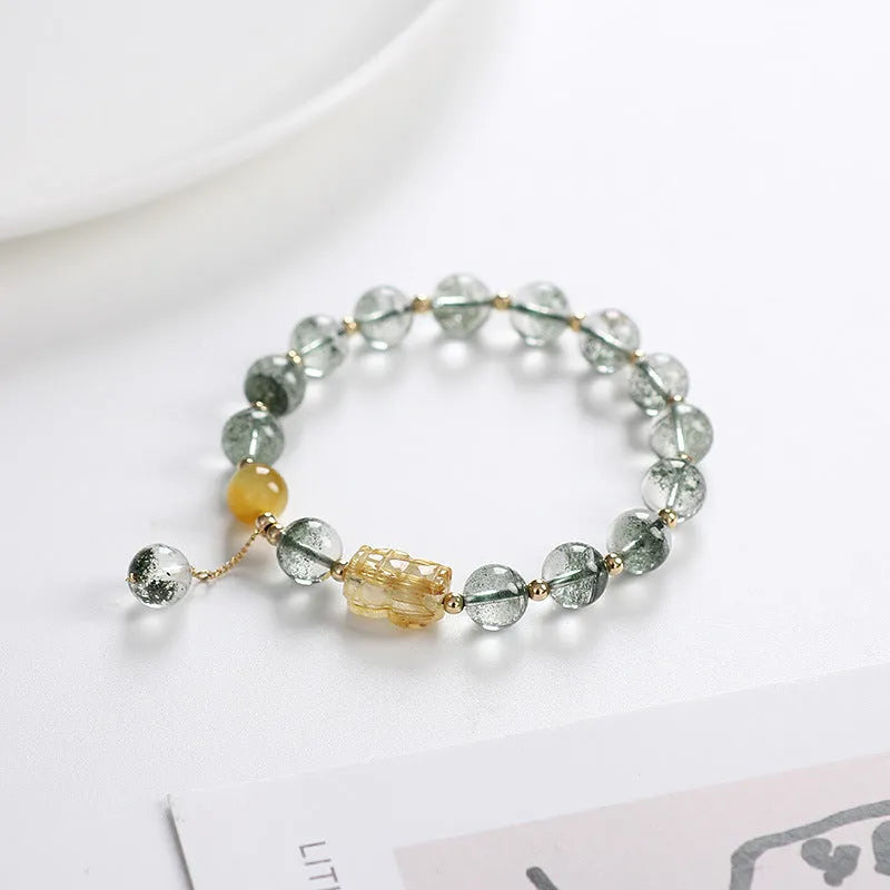 Green phantom quartz bracelet with 8mm geometric beads and gold rutile inclusions on wrist