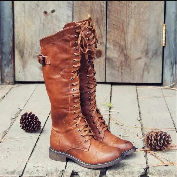 Women's black chunky heel high leg boots with a round toe and low heel on a plain background.