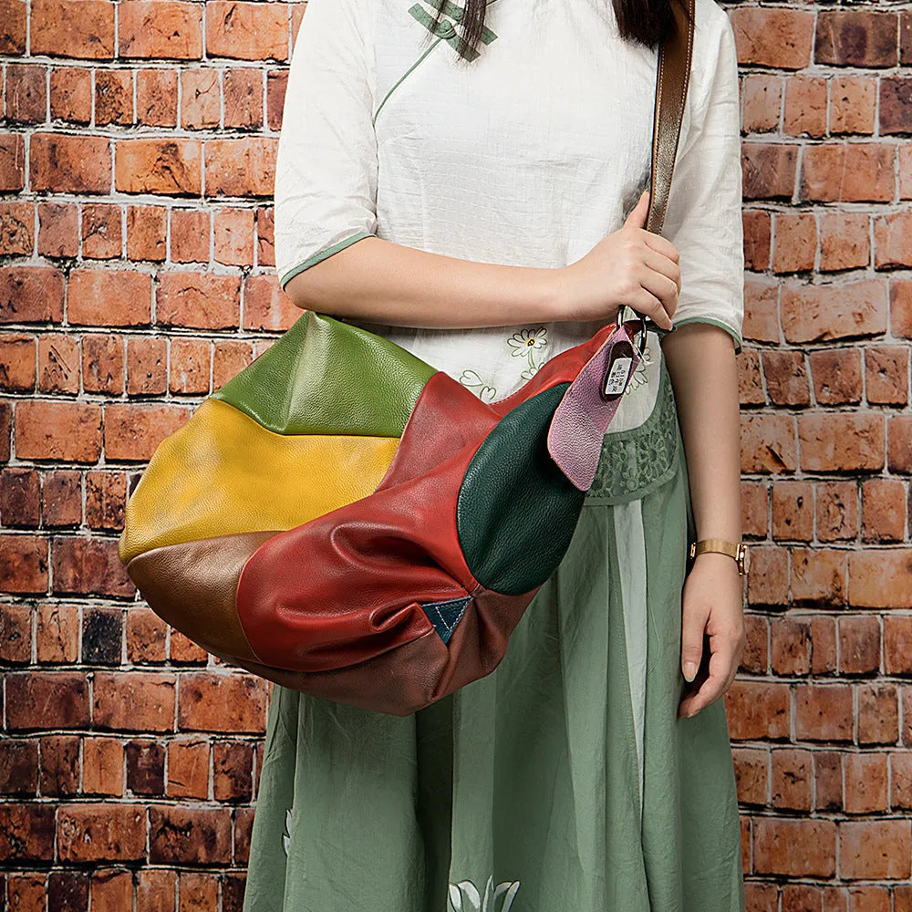 Brown cowhide leather crossbody travel bag with a laptop compartment, shown with adjustable strap.