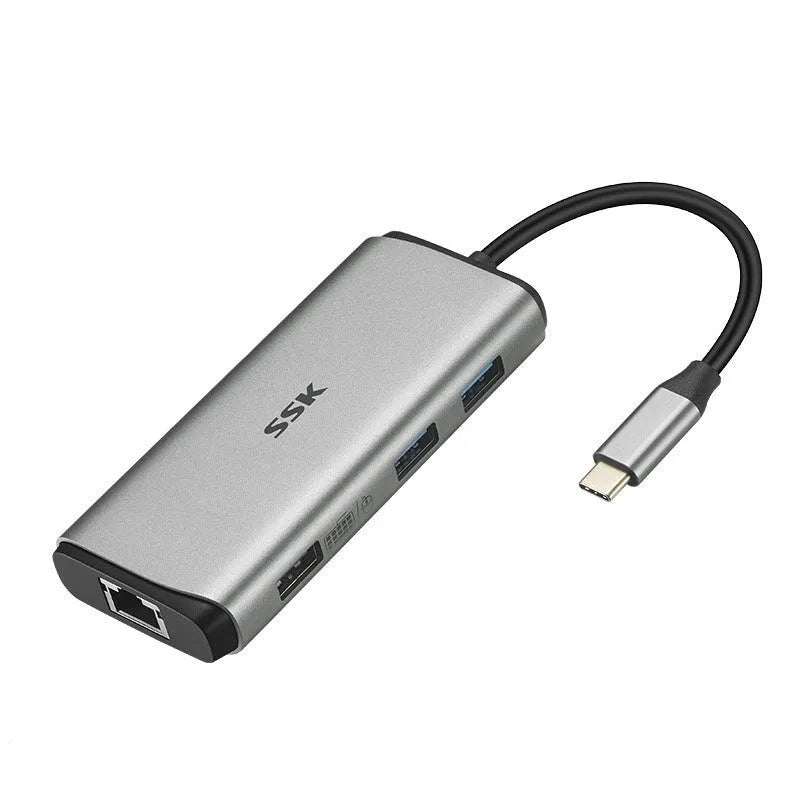 Grey 11-in-1 USB-C docking station with HDMI, VGA, USB ports, Ethernet, and card reader on a desk.