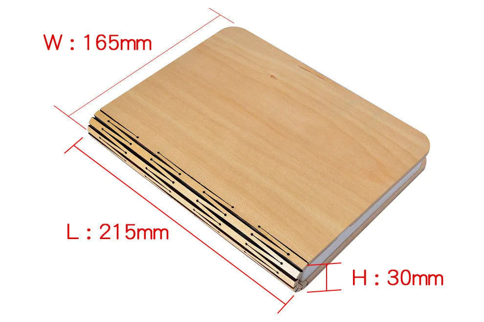 Walnut wooden book light open with colour changing LED pages on a desk