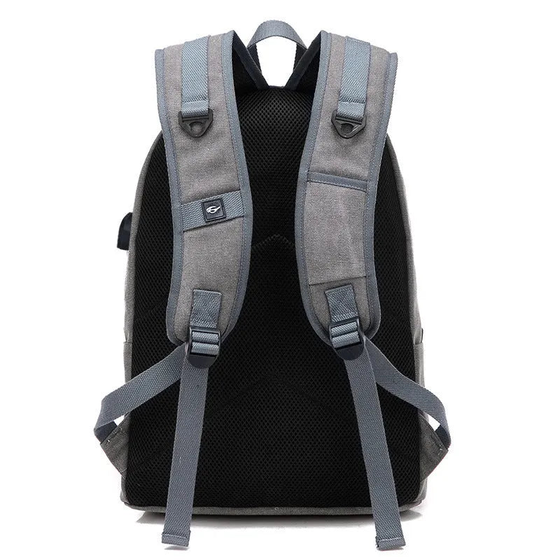 Canvas backpack with USB charging port showing laptop compartment and multiple pockets