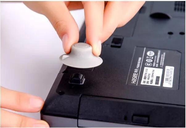 Grey durable plastic laptop cooling pads, two large and two small, on a table.