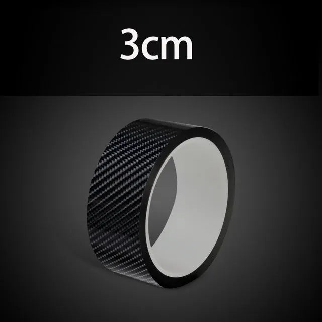 Black carbon fiber self-adhesive anti-collision decorative strip roll for car door threshold and bumper edge protection.