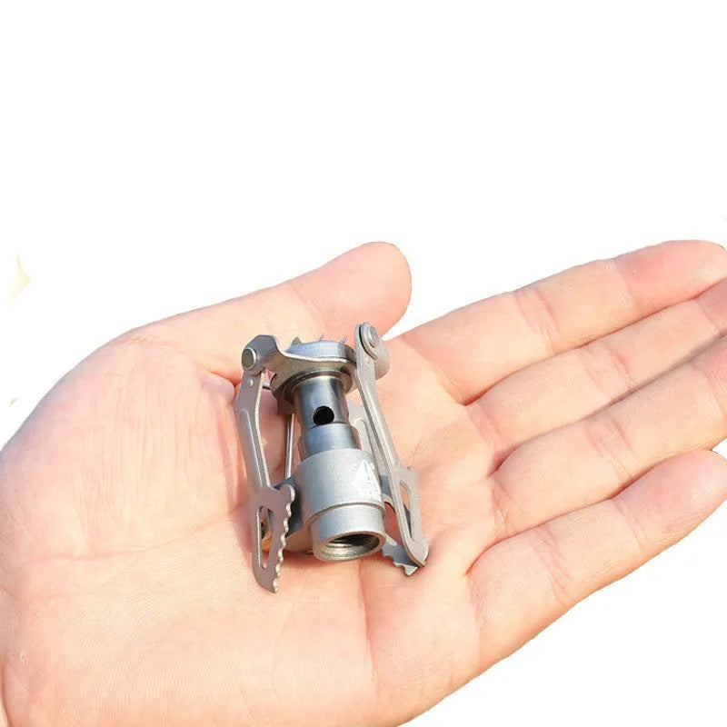 Portable propane gas camping stove with a one-piece burner unit.