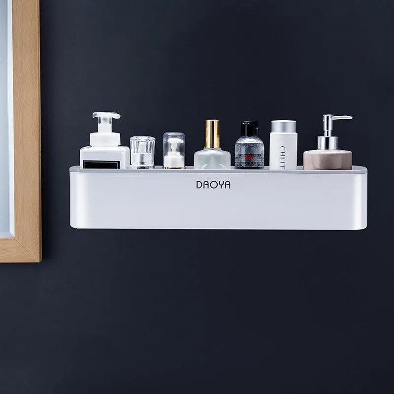 Black adhesive plastic bathroom shelf mounted on a wall holding shampoo and shower gel bottles.