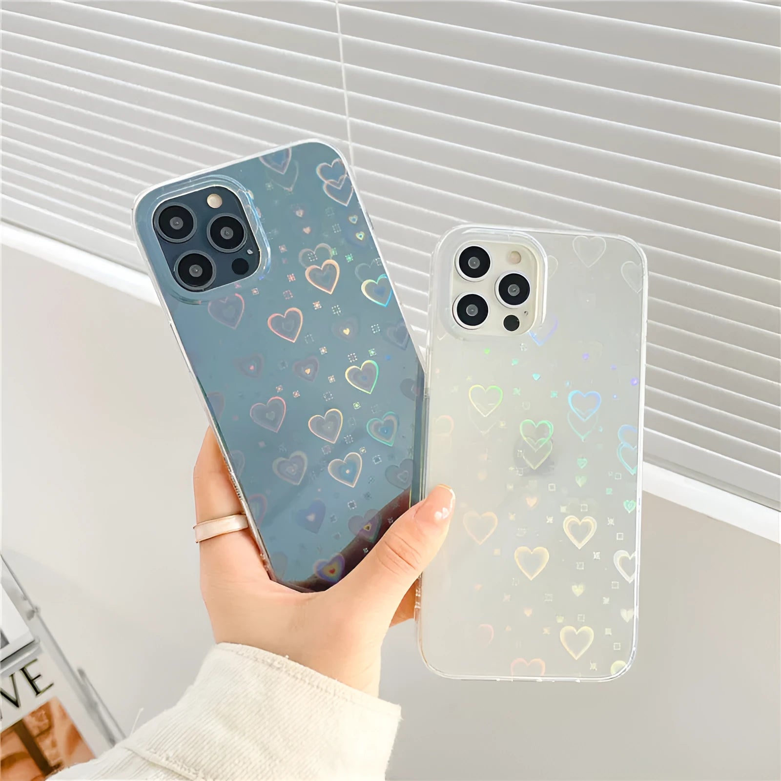 Transparent silicone iPhone case with a colourful laser love heart pattern on a table.