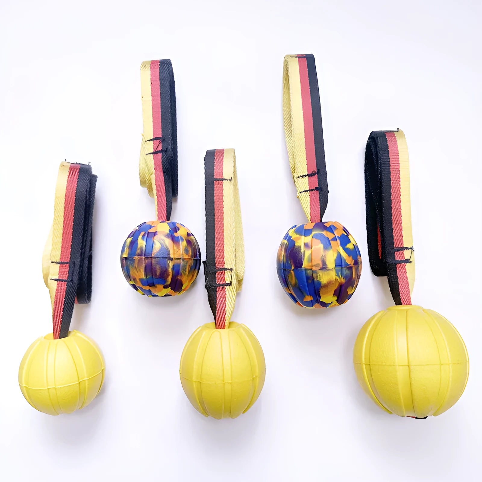 Yellow and camouflage coloured EVA floating dog tetherballs in different sizes on a blue background.