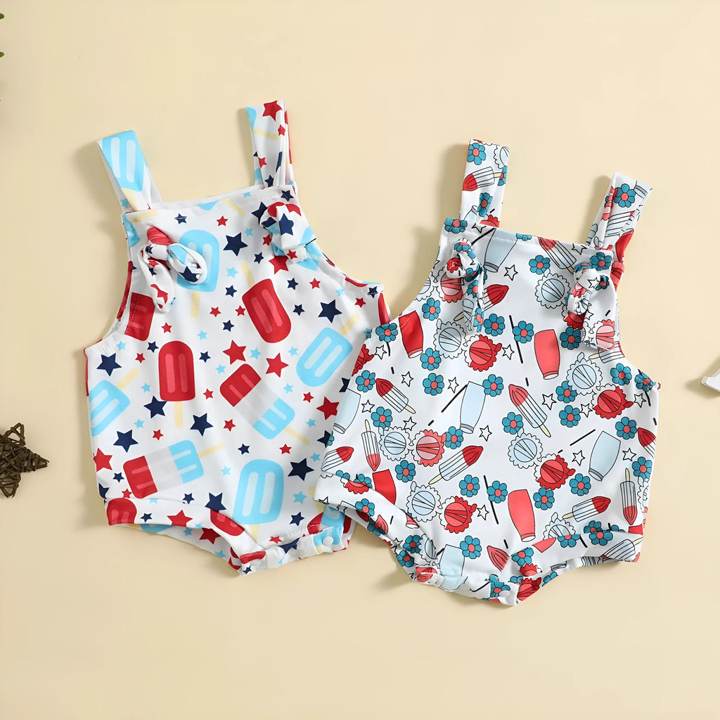 Baby girl wearing a sleeveless knotted front suspender pants jumpsuit in a printed design.