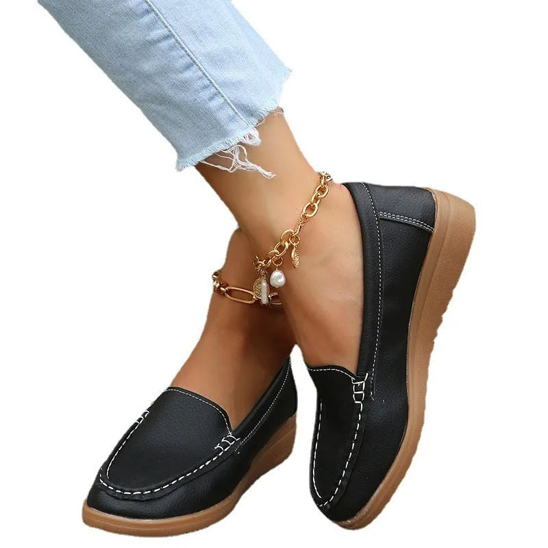 Women's flat PU leather loafers in multiple colours showing round toe and car suture detail.