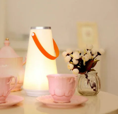 White USB rechargeable LED bedside night light with touch control on a wooden table.