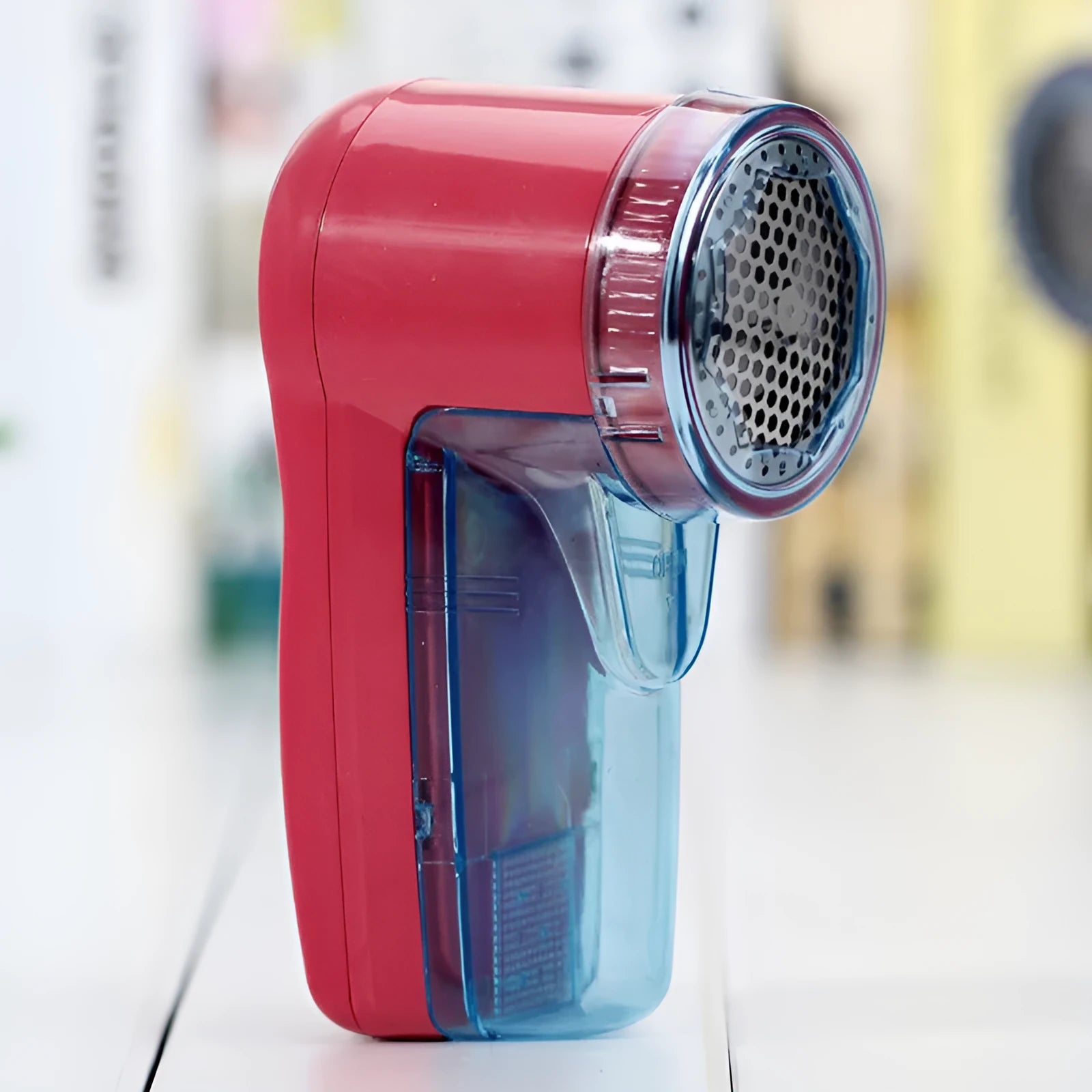 Portable electric clothing lint remover device on a white background