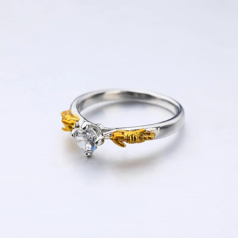 Black gold crystal crown ring on a finger, showing copper metal and decorative stones.